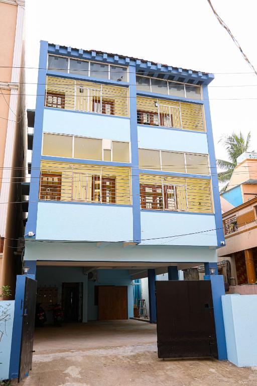 a blue building with wooden balconies on it at Redfox Service Apartment - Ambattur in Jāmb