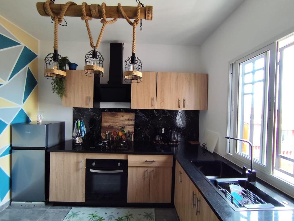 a kitchen with wooden cabinets and a black counter top at Akany Tsitoha in Tanjombato