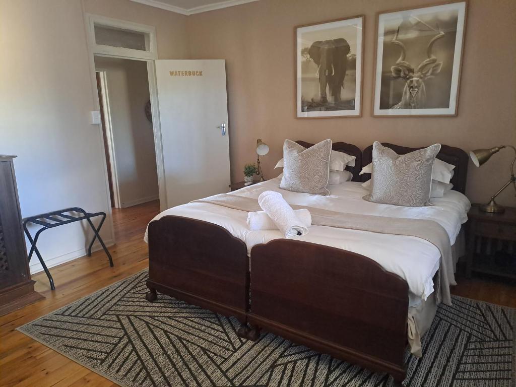 a bedroom with a large bed with two towels on it at The Ranch House at African Safari Lodge in Grahamstown