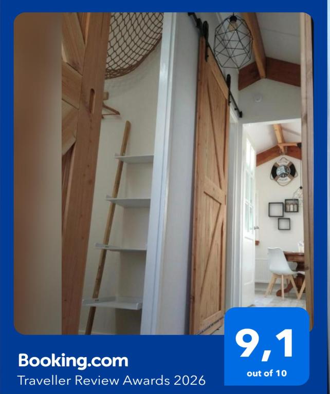 ajar door in a room with a ladder in it at B&B Buiten Gewoon Callantsoog in Callantsoog