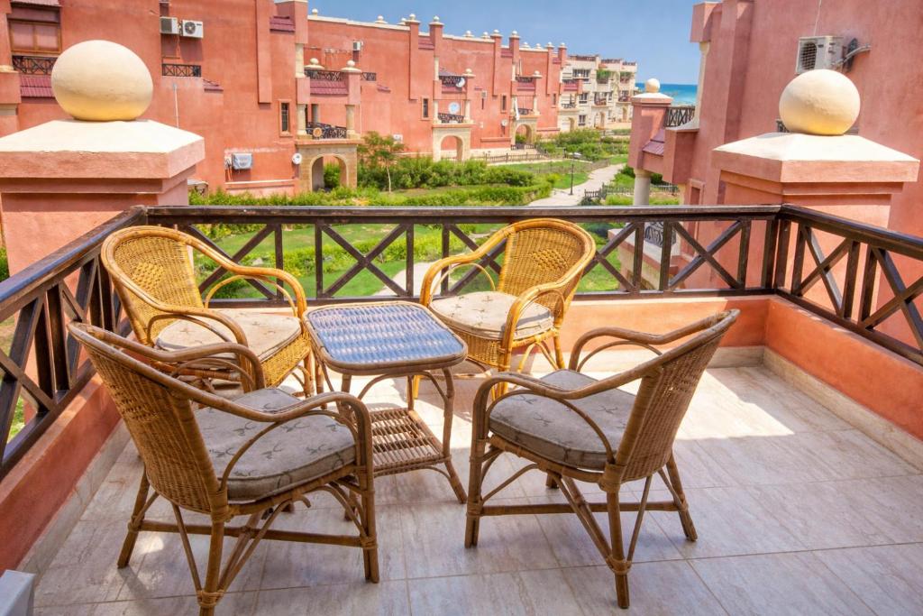 a group of chairs and tables on a balcony at Lazorde Bay Apartment in El Alamein