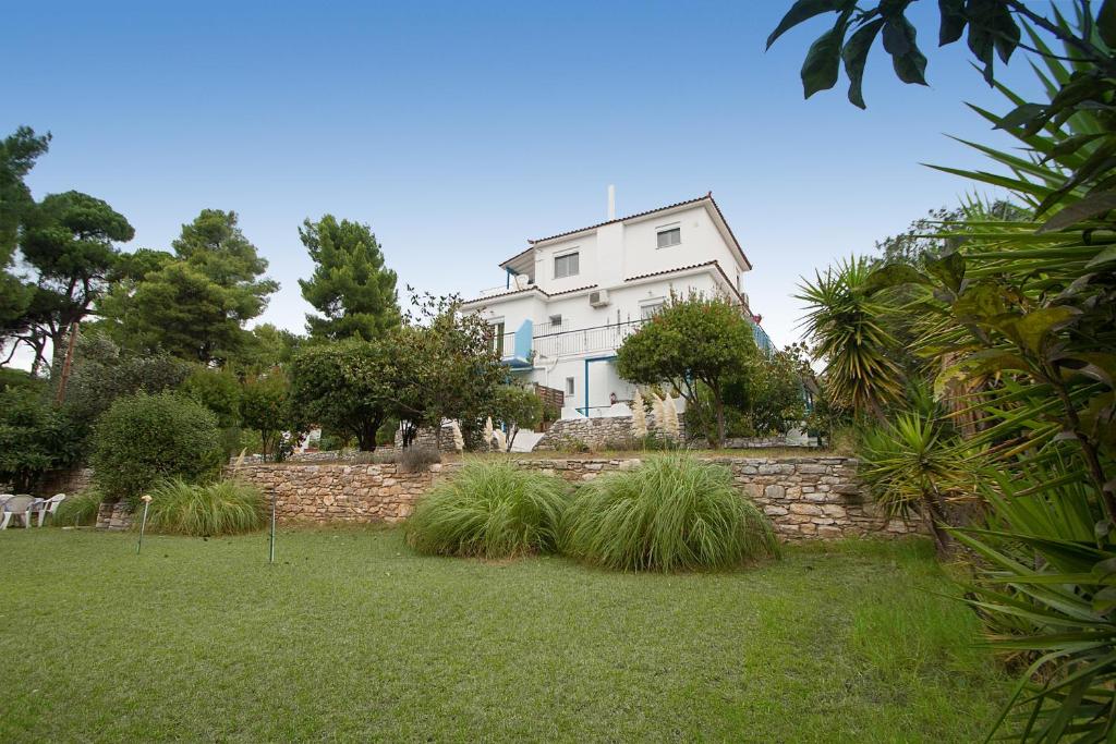 a large white house on top of a stone wall at Villa ALEXIS in Koukounaries