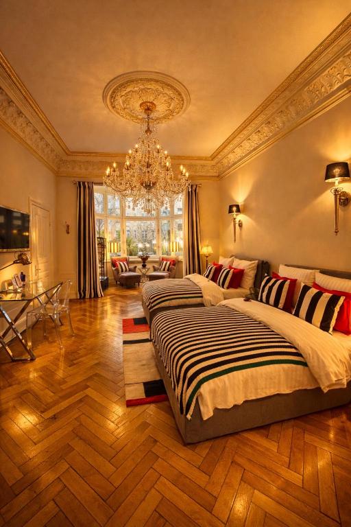 a large bedroom with two beds and a chandelier at Sleephotels Alsterroom in Hamburg