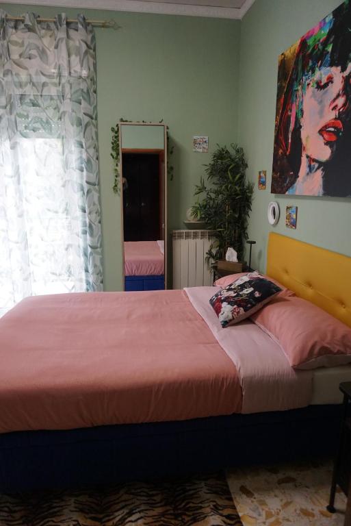 a bedroom with a bed with a pink bedspread and a mirror at Nice room with private bathroom in Ercolano