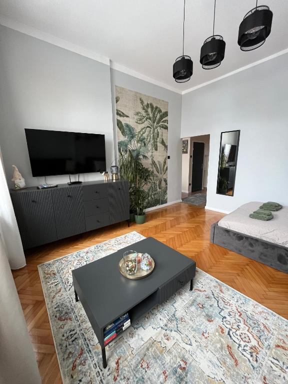 a living room with a black coffee table and a flat screen tv at Old Town Rynek Apartament in Grudziądz