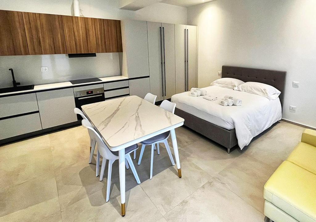 a bedroom with a bed and a table and a kitchen at Boutique Apartments Magenta in Magenta