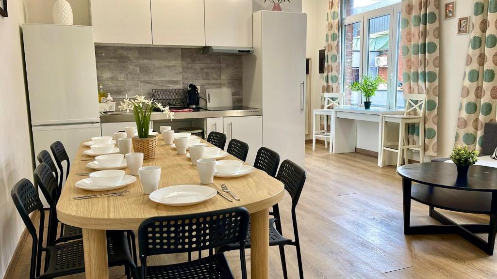 a dining room table with chairs and a kitchen at Сarnot Apartments ZOO Area in Antwerp