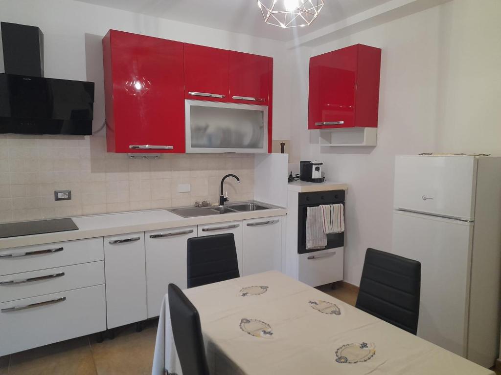 a kitchen with red cabinets and a table and a sink at Casa Molines in Giaveno