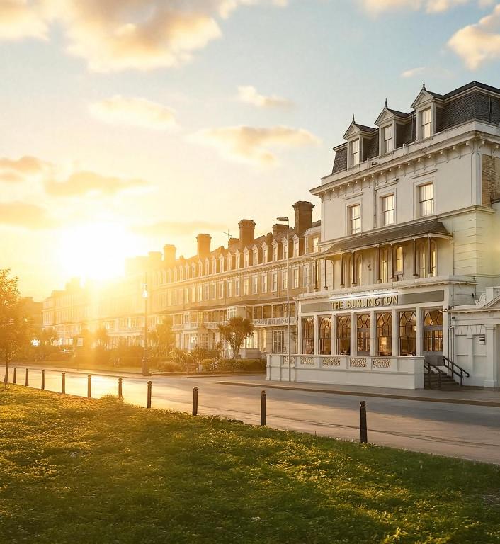 a building on a street with the sun in the background at The Burlington in Worthing