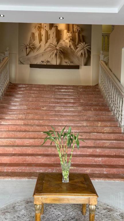 a potted plant sitting on a table in a staircase at وادي برزان للشقق المخدومة in Hail