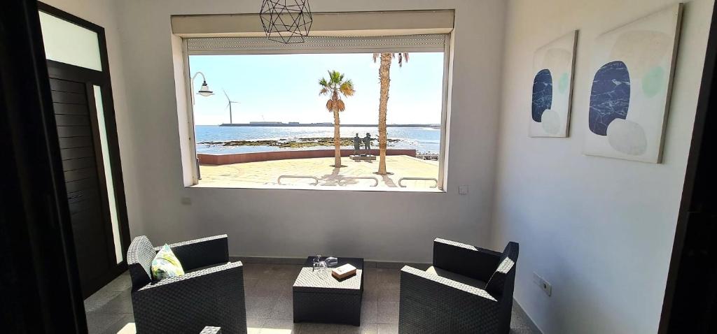 a room with a table and chairs and a window at Apartamento en primera línea de la playa in Arinaga