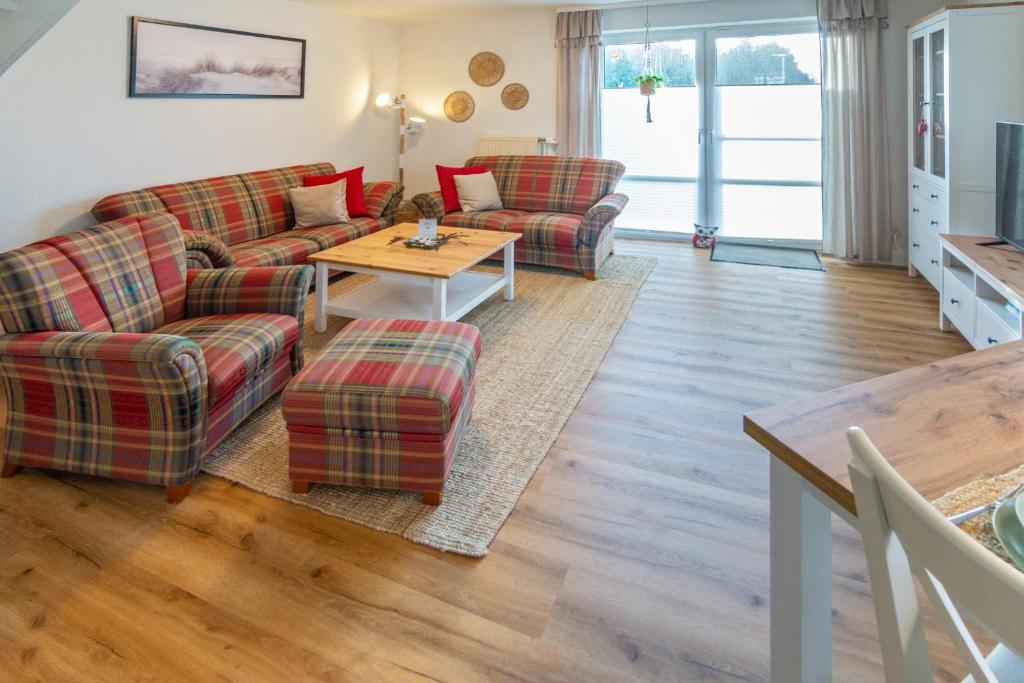 a living room with two couches and a table at Küstenkoje in Neßmersiel