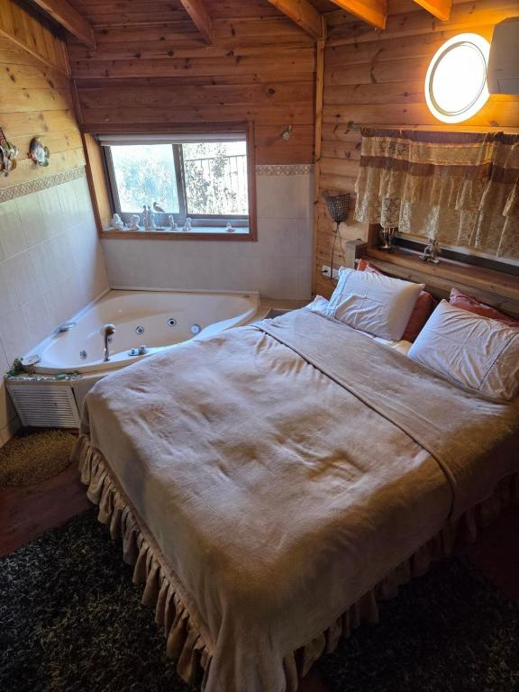 a bedroom with a large bed and a bath tub at Among the cherry trees B&B 6 - Nahal Dan in Metulla