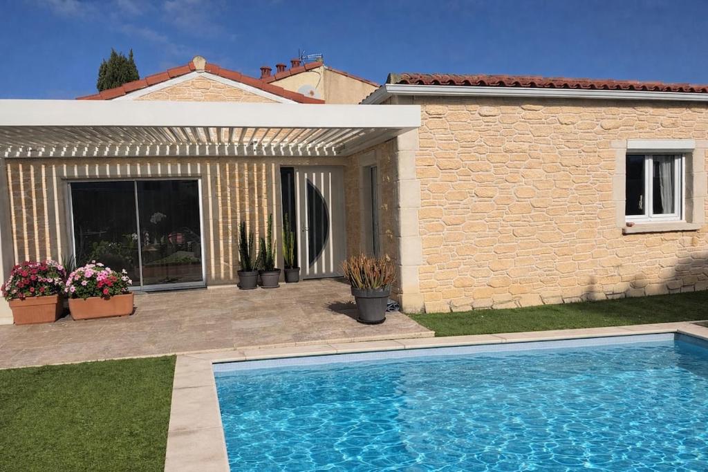 a swimming pool in front of a house at Maison individuelle piscine extérieure in Port-Saint-Louis-du-Rhône