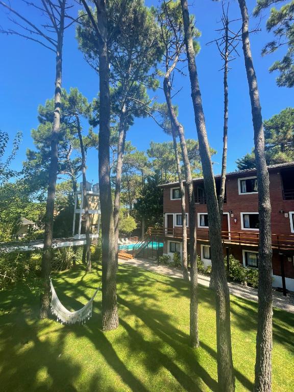 a group of trees with a hammock in a yard at Sintra Aparts in Mar de las Pampas