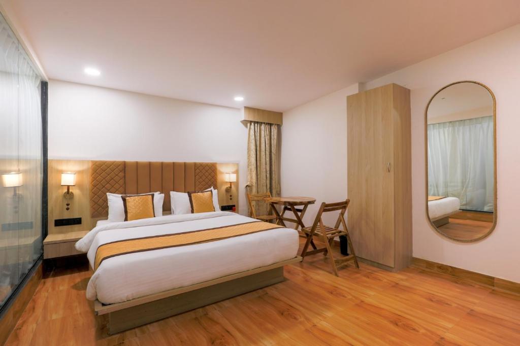 a hotel room with a bed and a mirror at De Classico Hotel Apartment in Mumbai