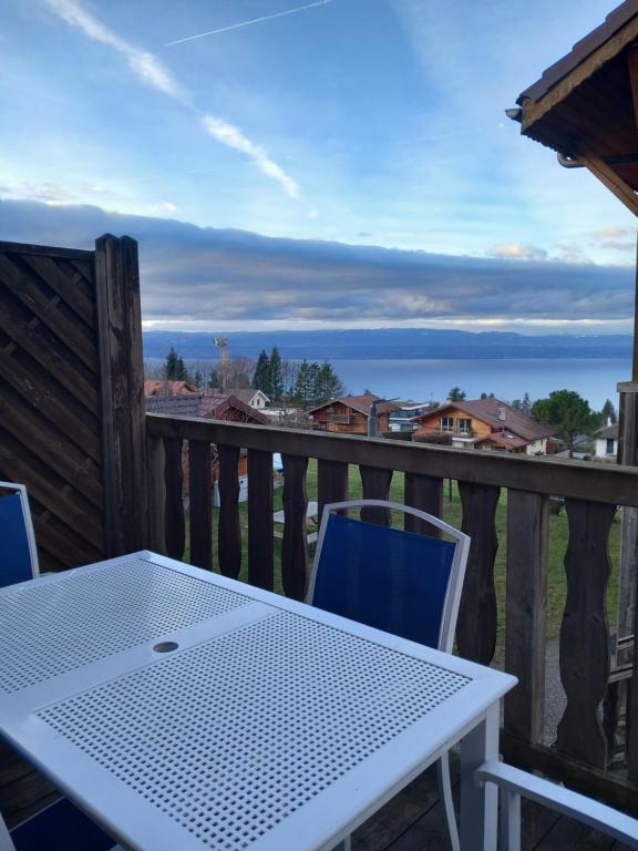 a table and chairs on a deck with a view of the ocean at Les chalets d Evian in Évian-les-Bains