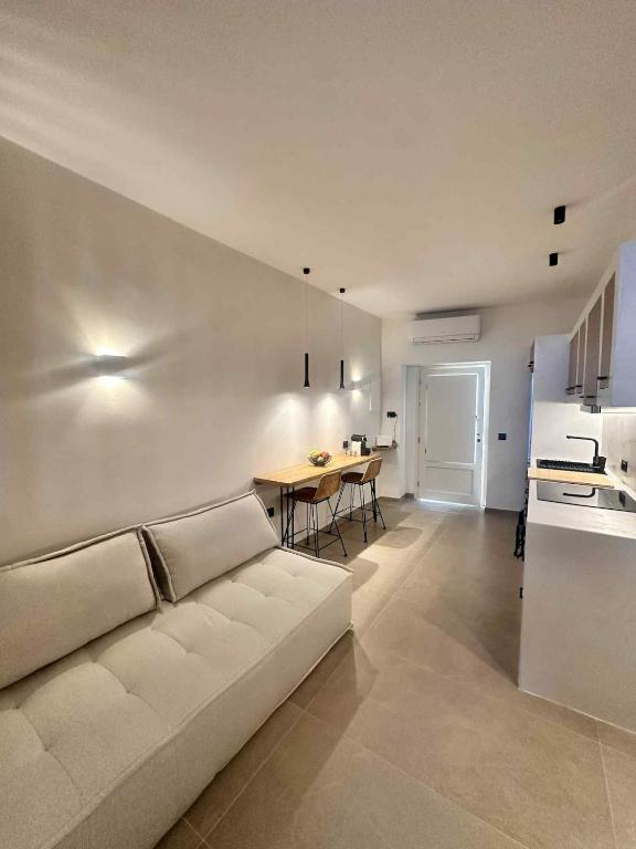 a living room with a white couch and a table at Little Kamara Ios in Ios Chora