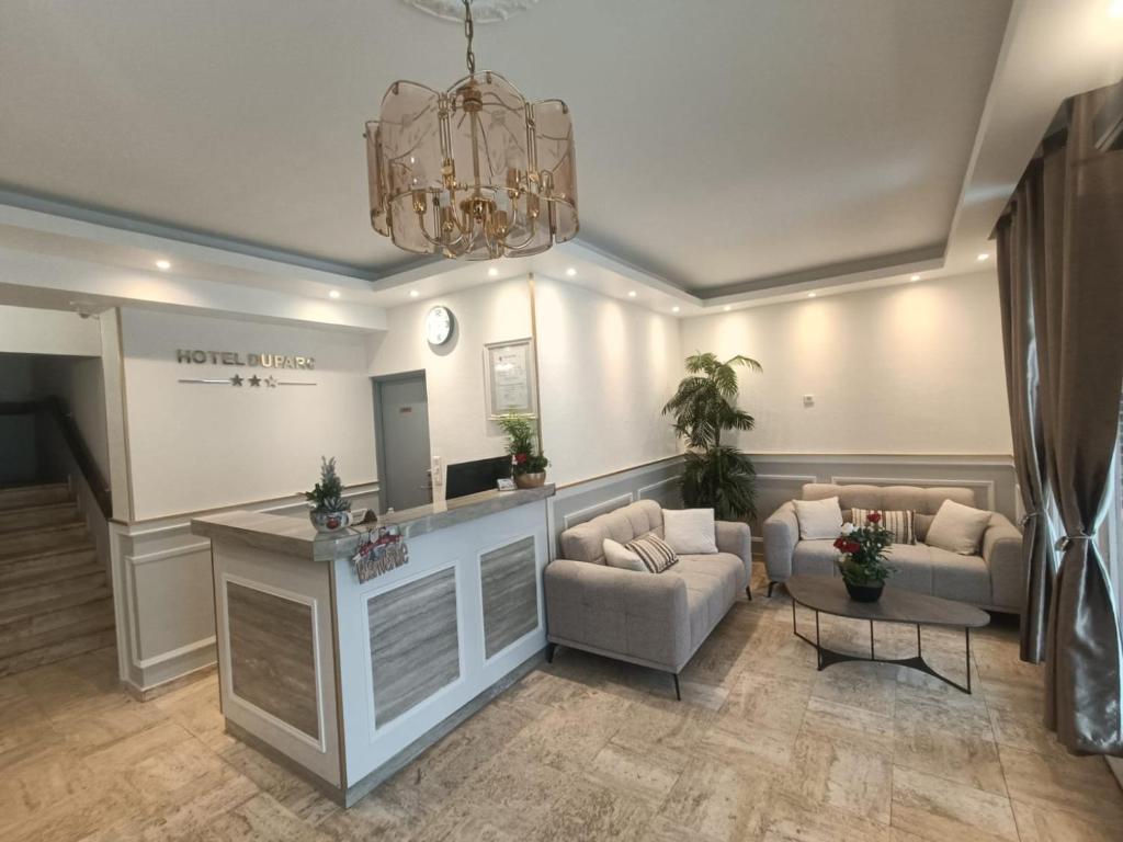 a large living room with couches and a chandelier at CITY PARC HOTEL - Proche Paris Nord & CDG Aéroport - Parc des Expositions in Aulnay-sous-Bois