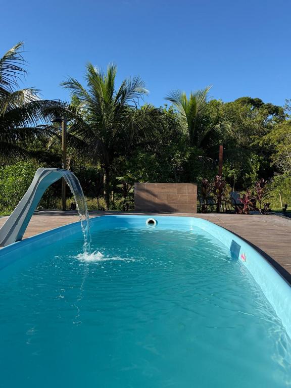a swimming pool with a water fountain at Recanto Tavares in Linhares