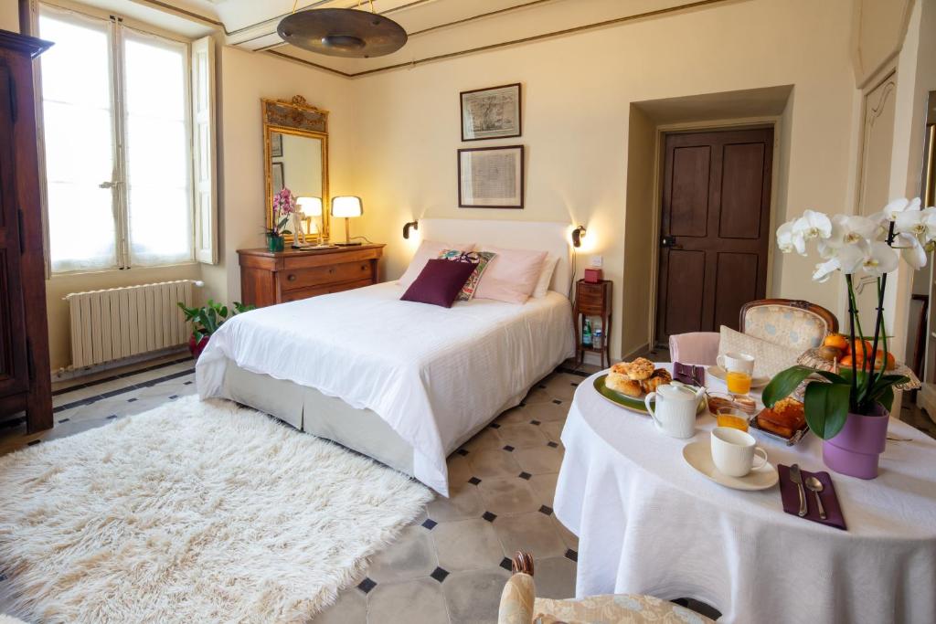 a bedroom with a bed and a table with food on it at Une chambre au Château in Cabriès