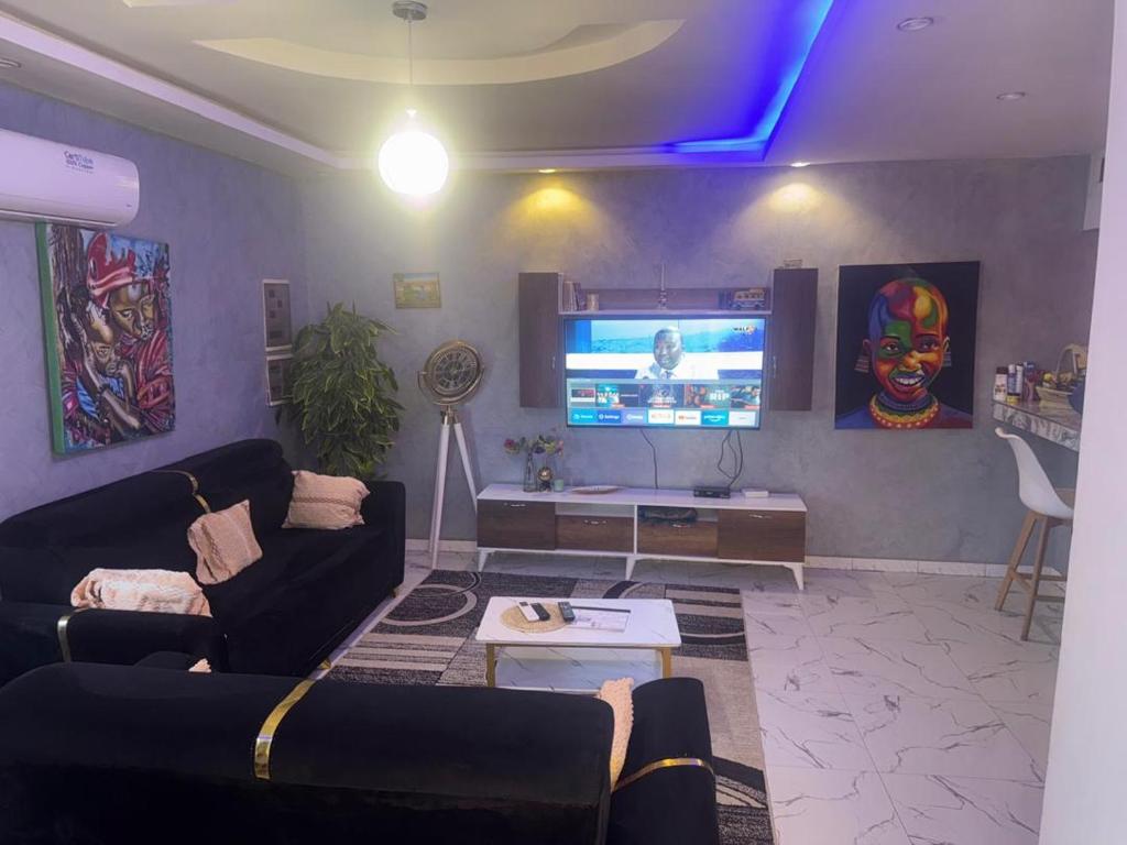 a living room with a couch and a flat screen tv at Appartement privatif À Mbour face RN1 in Mbour