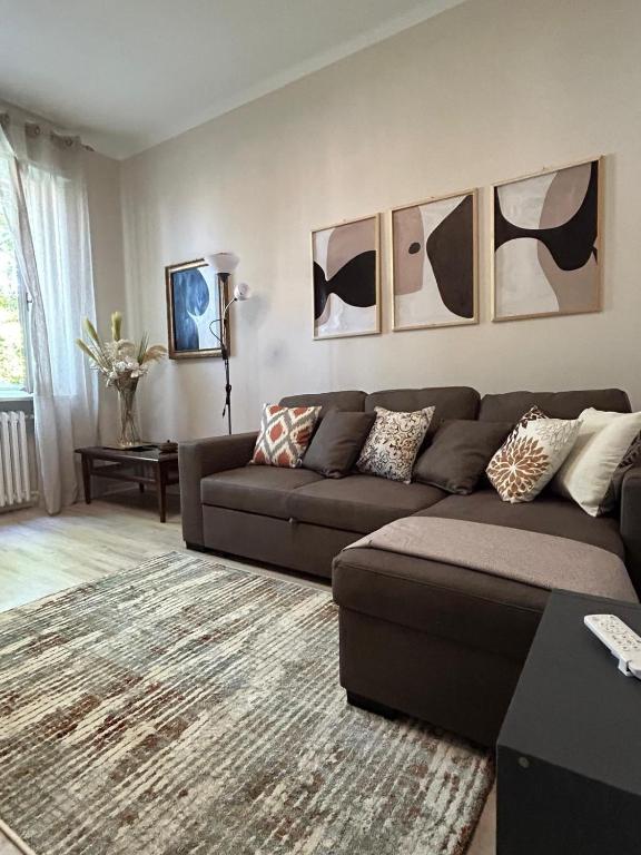 a living room with a brown couch and pictures on the wall at Casa Acqua e Sale - 50 mt dal mare in Fano