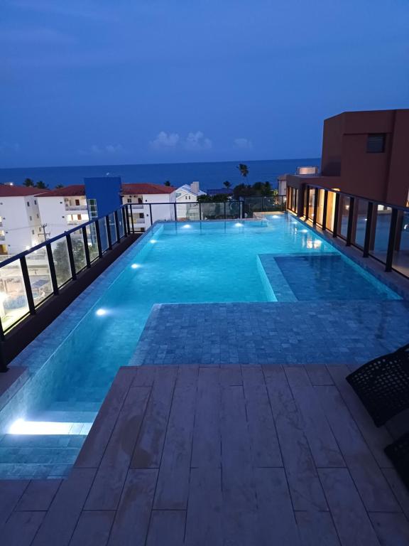 a swimming pool on the roof of a building at night at Flat em Tamandaré - 102 - Carneiros Beach Exclusive in Tamandaré