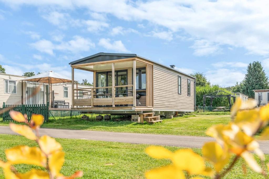 a tiny house with a black roof at Camping Papillon Bouillon - Vakantiehuis Premium Rustige Locatie in Bouillon