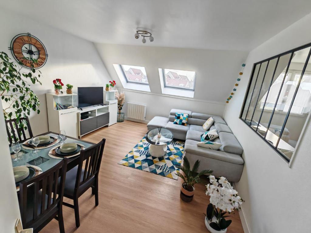 a living room with a couch and a table at Superbe cocon de 44m2 in Longvic