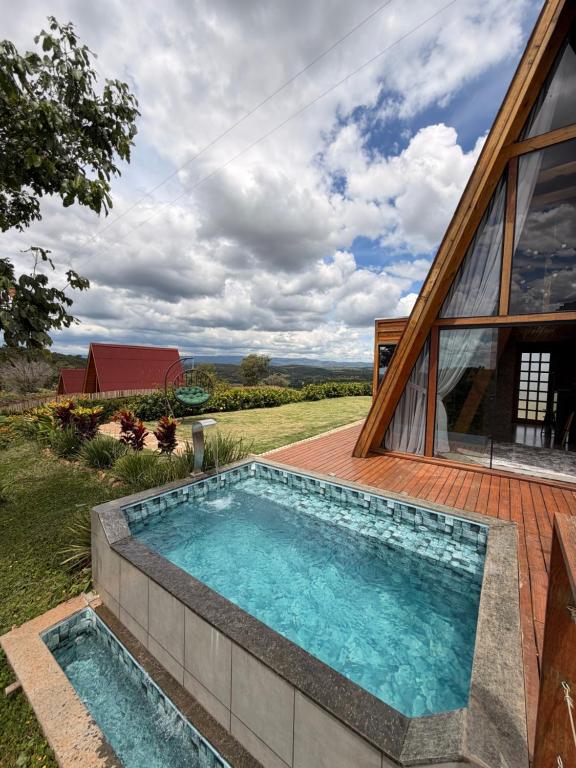 a swimming pool in the backyard of a house at Vale dos Ventos - Chalés e Hospedagem in Jaboticatubas