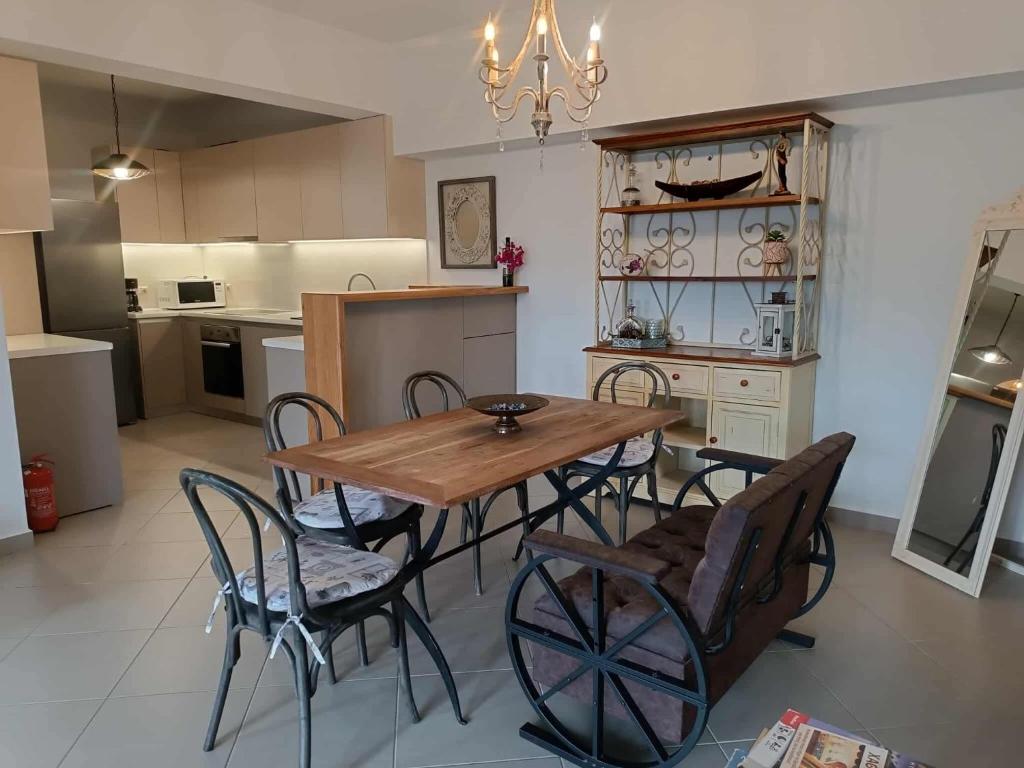 a kitchen with a wooden table and chairs at Argento in Vrontádos
