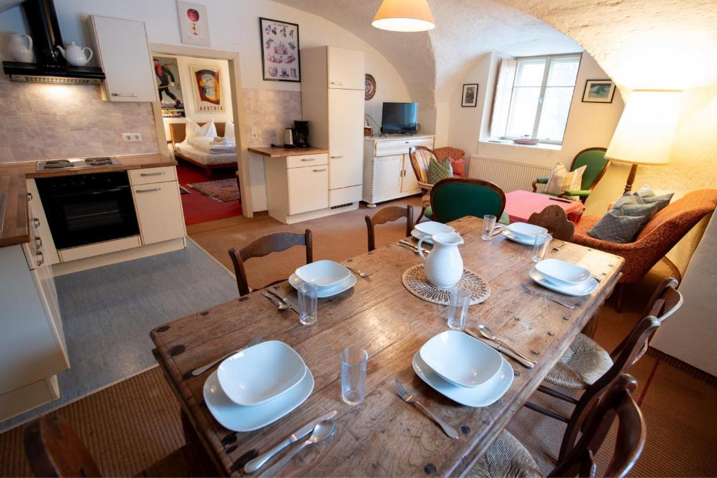 a dining room and kitchen with a wooden table and chairs at Ferienwohnung Ottmanach Josefhof in Pischeldorf