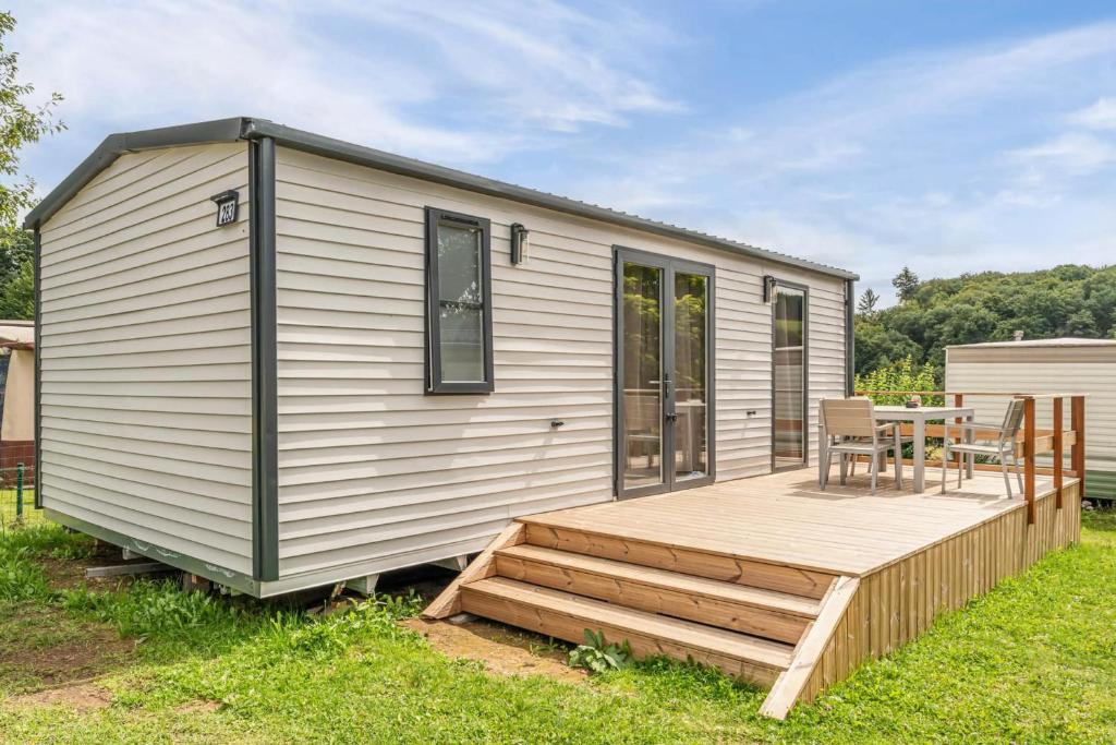 a tiny house with a deck and a table at Camping Papillon Bouillon - Vakantiehuis Relax 4P in Bouillon