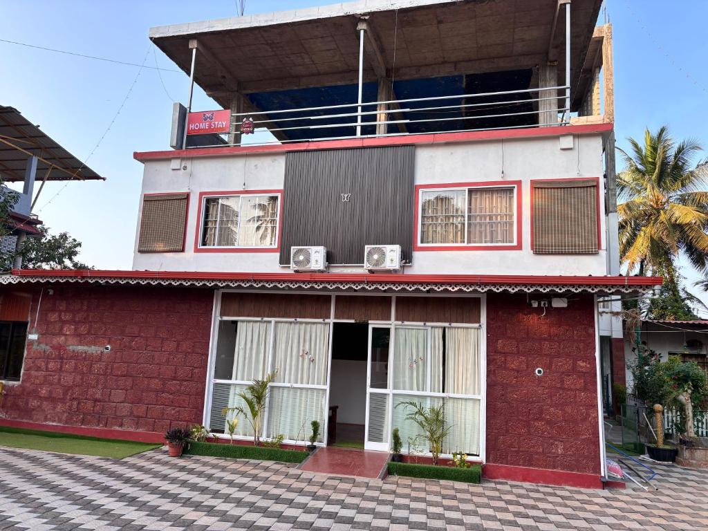 a red and white building with a balcony at Gokarna City Guest House in Gokarna