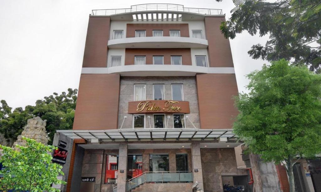 a tall building with a sign in front of it at Starlight Hotels Palm Tree Mylapore Ramakrishna Mutt Road chennai in Chennai