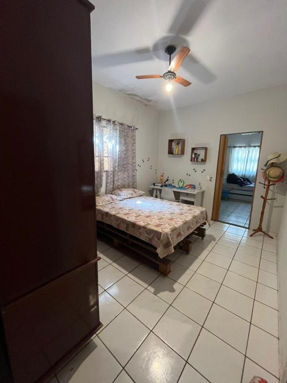 a bedroom with a bed and a ceiling fan at Suite in Catanduva