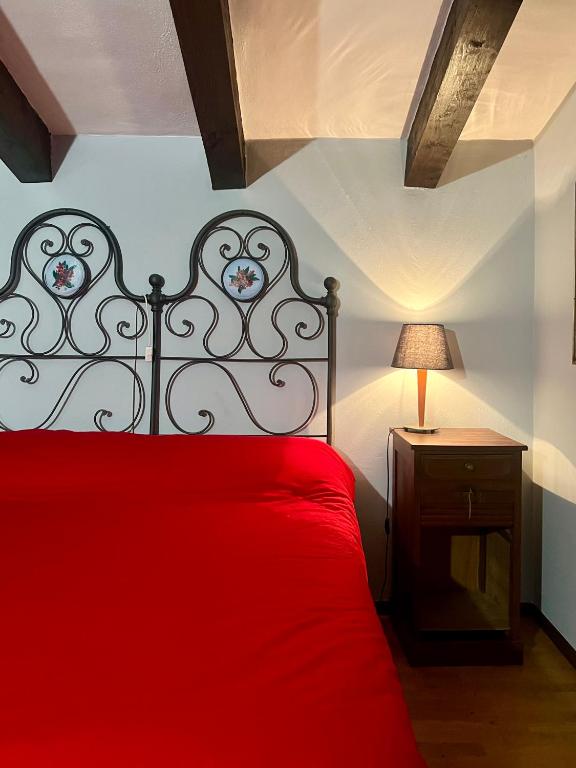 a bedroom with a red bed with a red blanket at Passeggiata al sole in Santa Maria Maggiore