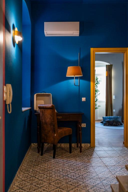 a blue room with a desk and a chair at The Urban Parrot Maisonette in Ermoupoli