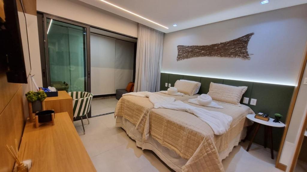 a bedroom with a large bed with two towels on it at Stúdio FRENTE MAR Centro de Convenções Salvador ArtStudio in Salvador