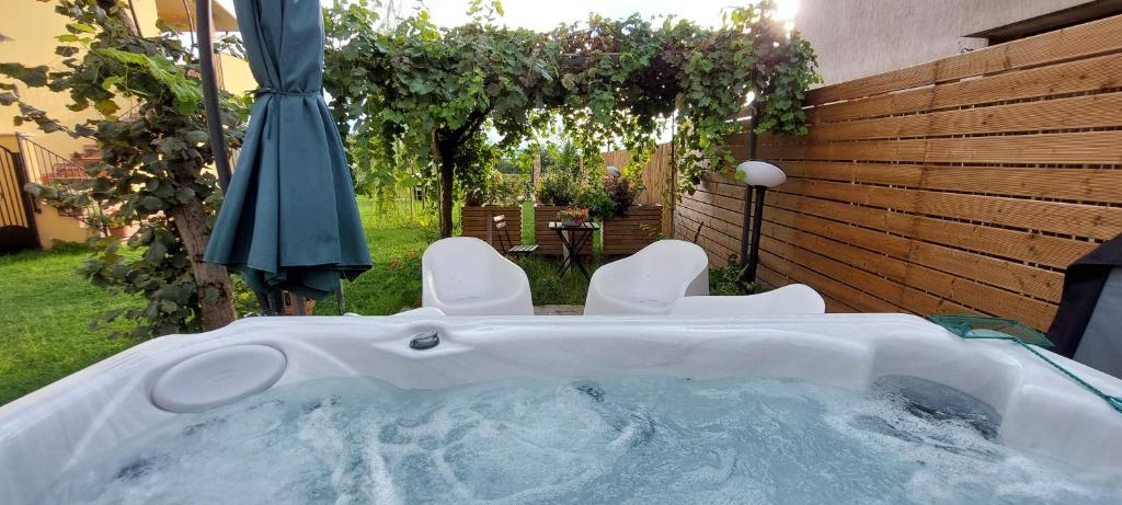 a hot tub in a yard with an umbrella at Home Nature and Relax in Monte del Lago