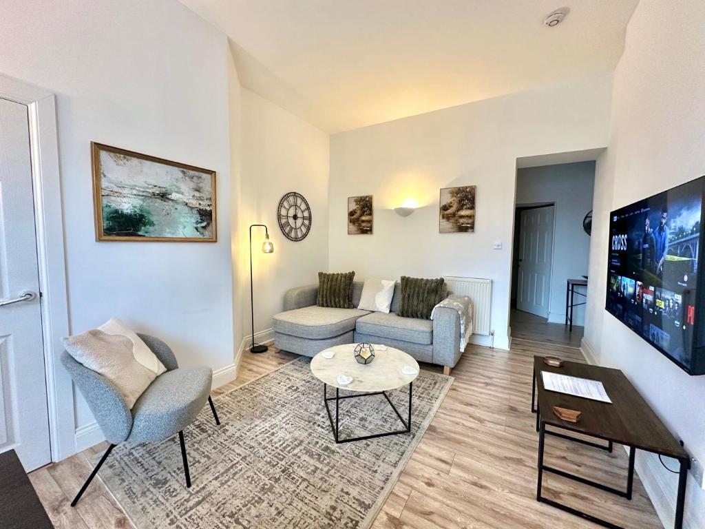 a living room with a couch and a table at The Tay Residence, City Centre in Perth