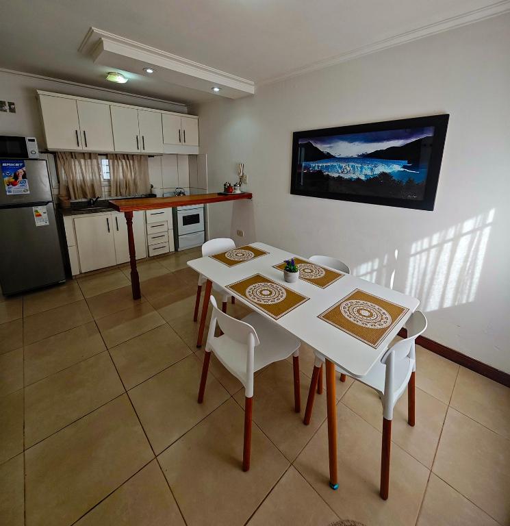 a kitchen with a white table and chairs in a room at Dpto URQUIZA Olavarría in Olavarría