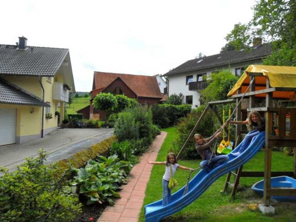 a group of people playing on a slide in a yard at Ferienhof Christmann in Mossautal