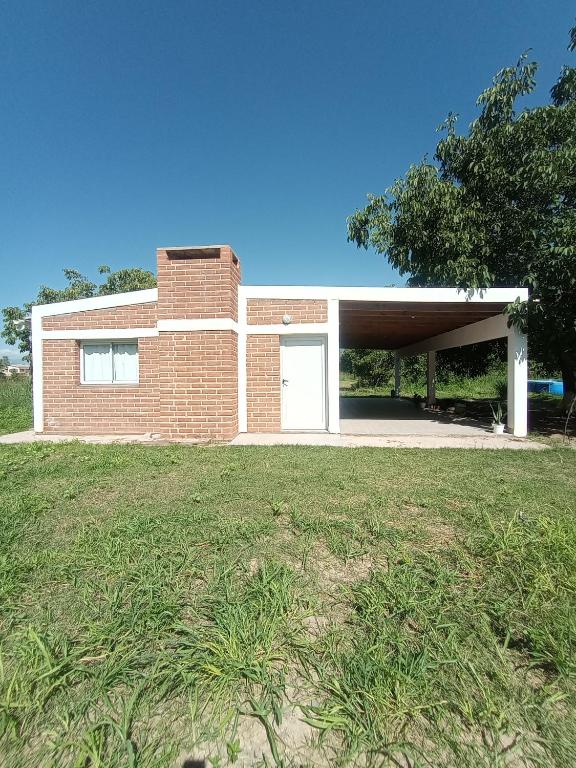 a brick house with a garage and a grass field at Casa Colmena Turismo Rural in Londres