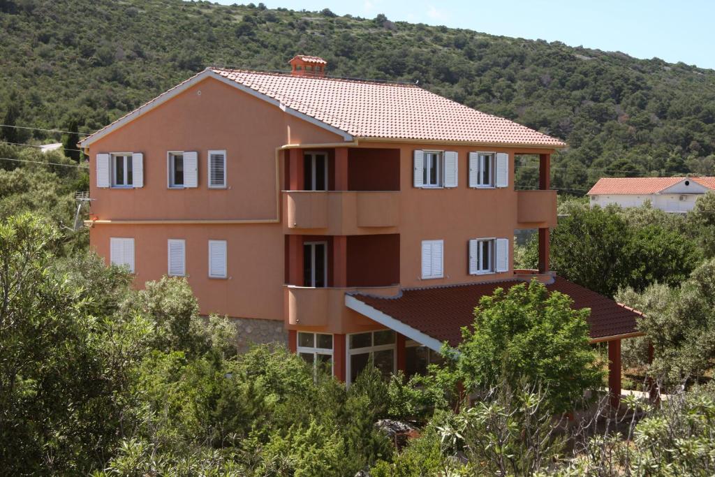 a house on a hill with trees at Apartments Milin in Božava