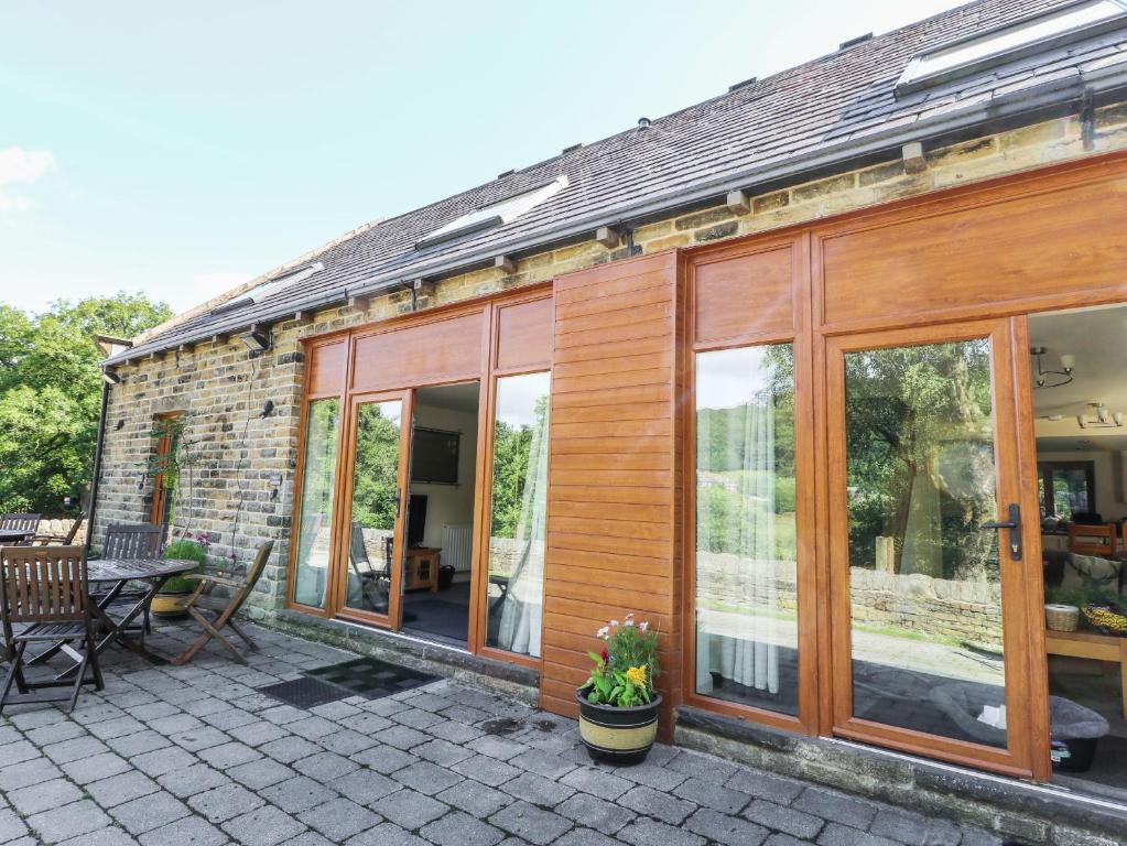 a house with glass doors and a patio at Cragg Hall View in Mytholmroyd