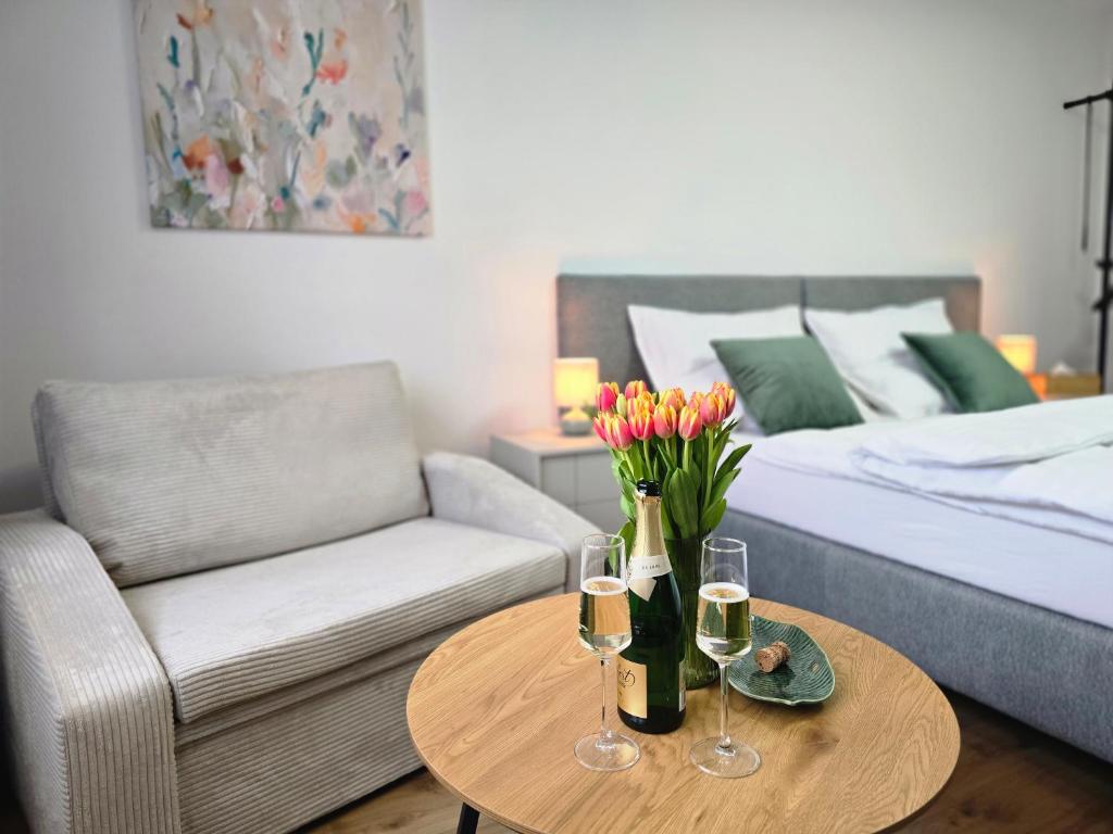 a living room with a couch and a table with wine glasses at Apartmány Baťovany in Partizánske
