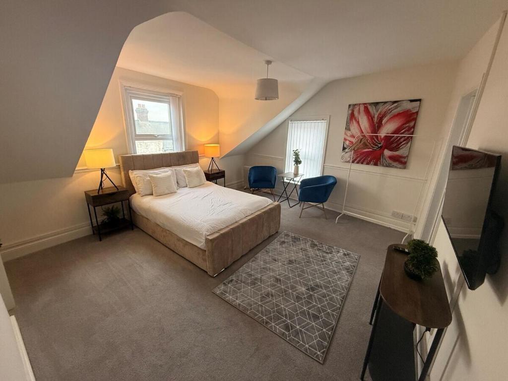 a bedroom with a bed and a table and chairs at The Loft Ashley Road in Poole