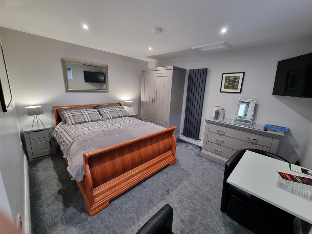 a bedroom with a bed and a dresser and a television at The Nook in Rostrevor